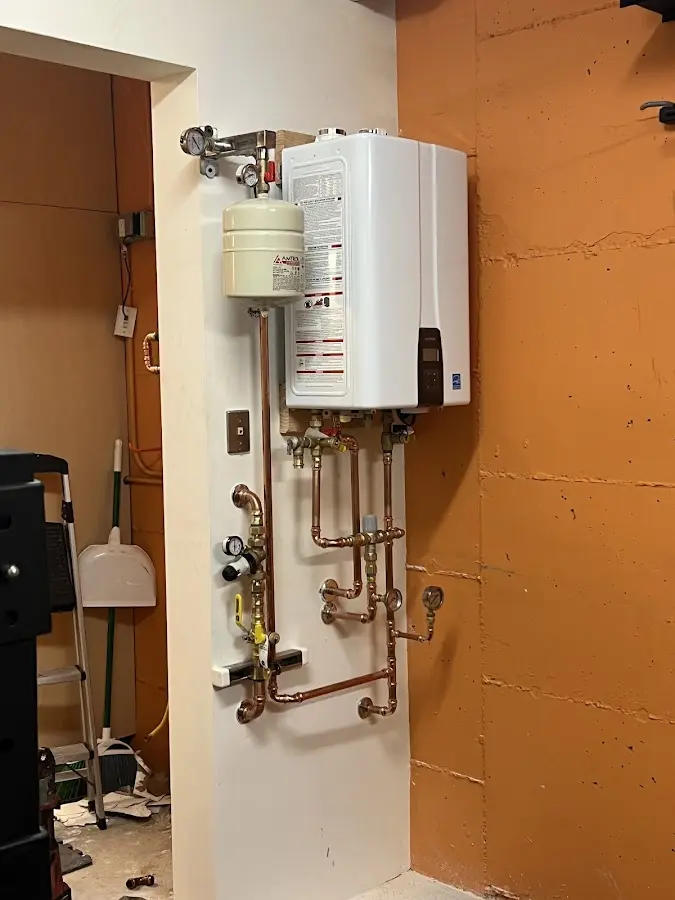 Plumbing technician inspecting water heater connections in Boonton